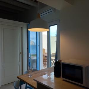 a living room with a table and a large window at AbuNagia seaside villa garden in Erice +17 photos