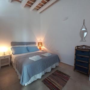 1 dormitorio con 1 cama con almohadas azules en AbuNagia seaside villa garden, en Erice