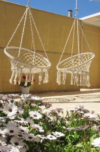 zwei Kronleuchter, die über einem Blumengarten hängen in der Unterkunft Broom House in San Foca
