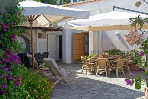an outdoor patio with a table and chairs and umbrellas at Casa il Terrazzino in Anacapri