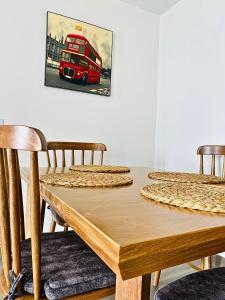 a wooden table with chairs and a red double decker bus at Apto pent-house amoblado para estrenar in Bogotá