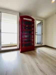 uma sala vazia com uma cabine telefónica vermelha em Apto pent-house amoblado para estrenar em Bogotá