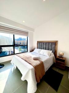 una camera con un grande letto e una grande finestra di Casa Turística en el Quindío a La Tebaida