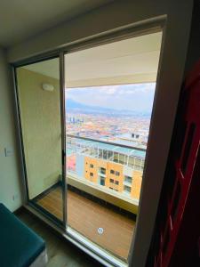 - une fenêtre dans une chambre avec vue sur la ville dans l'établissement Apto pent-house amoblado para estrenar, à Bogotá