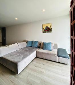 - une chambre avec un grand lit et un canapé dans l'établissement Apto pent-house amoblado para estrenar, à Bogotá