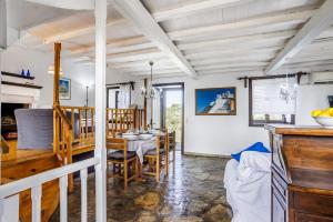 a dining room and living room with a table and chairs at Elli Cottage in Skopelos Town