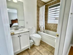 a bathroom with a sink and a toilet and a tub at House In Scarborough 20 Minutes to Downtown in Toronto