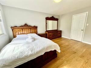 a bedroom with a large bed with a wooden headboard at House In Scarborough 20 Minutes to Downtown in Toronto