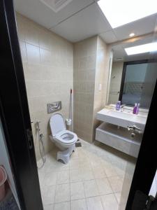 a bathroom with a toilet and a sink and a mirror at The blue residence in Abu Dhabi