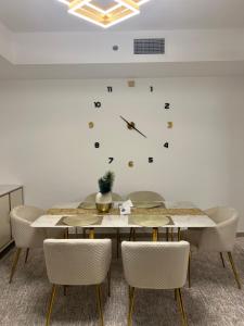 uma mesa com cadeiras e um relógio na parede em The blue residence em Abu Dhabi
