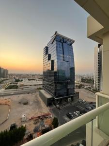 a tall glass building in a parking lot at The blue residence in Abu Dhabi