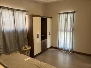 a bedroom with a bed and a door and windows at Chabayali House in San Juan del Sur