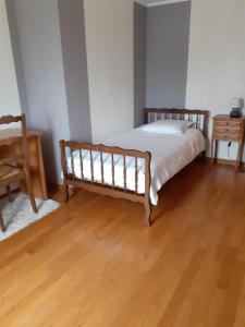 1 dormitorio con 1 cama y suelo de madera en A l'OREE DU BOIS, en Longwy