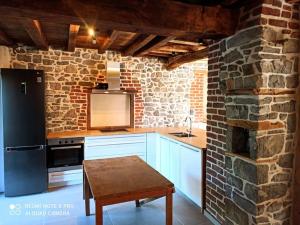 una cocina con armarios blancos y una pared de ladrillo en Ancienne ferme totalement rénové moderne à Baelen, en Baelen