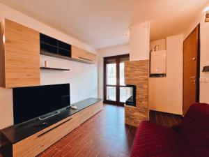 a living room with a tv and a red couch at Finestra su Villalago in Villalago