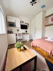 Un dormitorio con una cama y una mesa con flores. en R4 - Newly Renovated Private self contained Room in Selly Oak Birmingham, en Birmingham