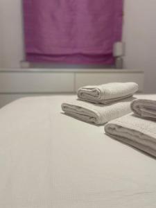 three towels sitting on top of a bed in a bathroom at Disfrutar de la playa in Playa de Gandia
