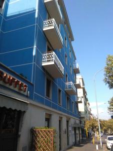 un edificio azul con balcones blancos en una calle en FamilyBed Roma Monteverde-Vaticano, en Roma