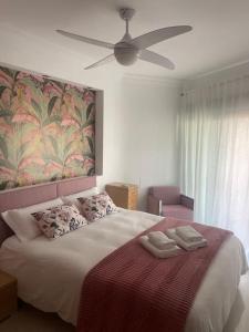 a bedroom with a large bed with a ceiling fan at Disfrutar de la playa in Playa de Gandia