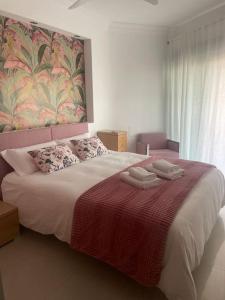 a bedroom with a large bed with two towels on it at Disfrutar de la playa in Playa de Gandia