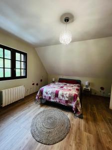 a bedroom with a bed and a rug at Maison chaleureuse dans un écrin de verdure 