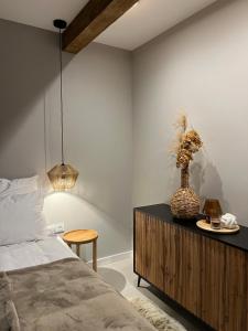 a bedroom with a bed and a vase on a cabinet at Apartament Uzdrowiskowa I Prestige in Szczyrk