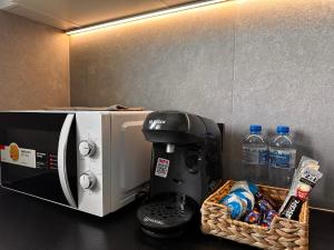 a coffee maker and a basket of water bottles at Apartament Center Starowiślna in Krakow