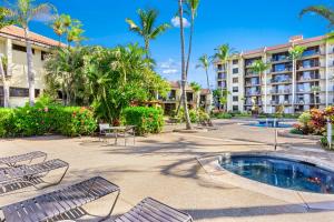 um resort com piscina, cadeiras e palmeiras em Maui Beach Vacation Club em Kihei