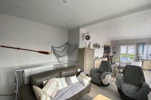 ein Wohnzimmer mit einem Sofa und 2 Stühlen in der Unterkunft Family nest located in Hermanville-sur-mer in Hermanville-sur-Mer