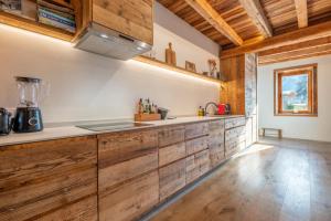 - une cuisine avec des placards en bois et un comptoir dans l'établissement Pretty loft with view of Mont Blanc & glacier, à Chamonix-Mont-Blanc
