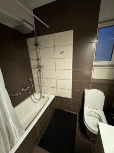 a bathroom with a tub and a toilet and a sink at Athens Gate Acropolis One bedroom apartment in Athens