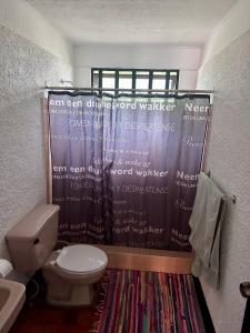 a bathroom with a toilet and a shower curtain at APARTAMENTOS VERANERA in Río Oro