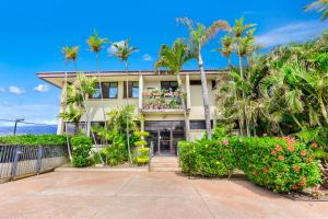 Maui Beach Vacation Club في كيهي: بيت فيه نخيل وبلكونه