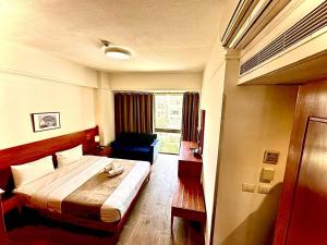 1 dormitorio con 1 cama y 1 silla en una habitación en Caesar's Park Hotel, en Beirut
