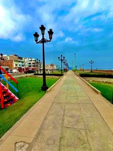 una acera con luces de calle en un parque en 100- departamento céntrico en chorrillos, en Lima