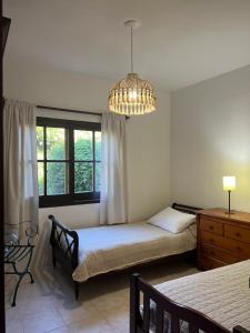 1 dormitorio con cama y lámpara de araña en Macondo entre cerros y mar, en Piriápolis