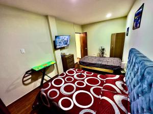 um quarto com uma cama com um edredão vermelho e branco em 100- departamento céntrico en chorrillos em Lima