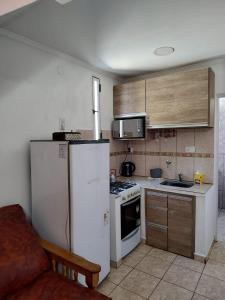 a kitchen with a white refrigerator and a stove at Departamentos Anahí in Río Colorado