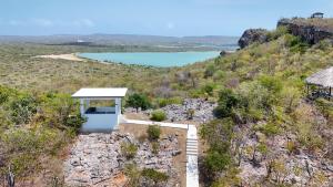 a small white building on a hill with a lake at Coral Estate Holidays in Willibrordus