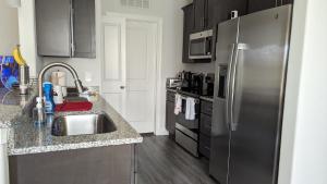 a kitchen with a sink and a stainless steel refrigerator at CoZy One Bedroom Apartment Exquisite in Raleigh