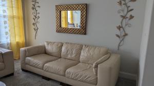 a brown couch in a living room with a mirror at CoZy One Bedroom Apartment Exquisite in Raleigh