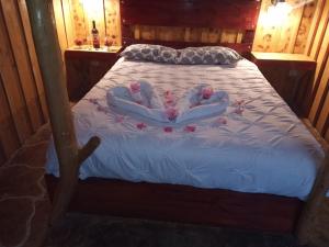 a bed in a wooden room with flowers on it at Finca Valle Arcoiris in Heredia