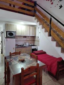 a kitchen with a dining room table and a staircase at Departamentos Anahí in Río Colorado