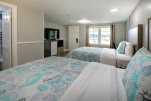a hotel room with two beds and a television at Windrift Motel in West Yarmouth