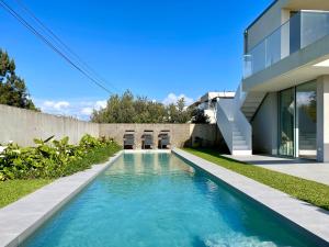 a swimming pool in front of a house at Villa Mar & Luz, Porto, Mindelo Beach in Mindelo