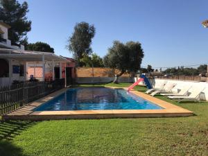 una piscina con un tobogán en un patio en Villa Cortijo El Torreon, en Utrera