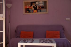 a bedroom with a blue couch and a table at Apartamento Tortuga Carey in Tarifa