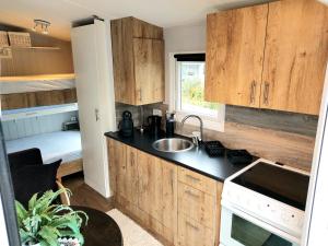 a small kitchen with wooden cabinets and a sink at Microhouse Leknes in Lofoten in Leknes