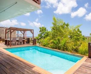 a swimming pool on a deck with a table and chairs at Two Bedroom app Villa Islandessa in Willemstad
