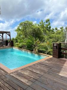 a swimming pool with a wooden floor and a wooden deck at Two Bedroom app Villa Islandessa in Willemstad